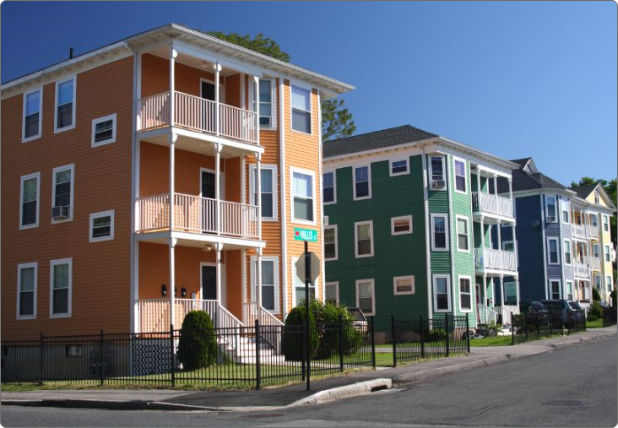 Two parents help their child ride a bike